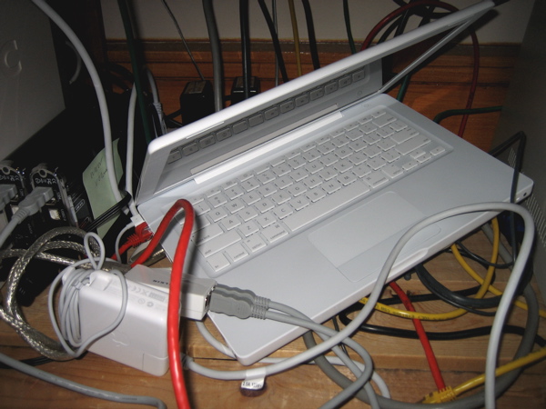 laptop in a mess of cables and hard drive enclosures